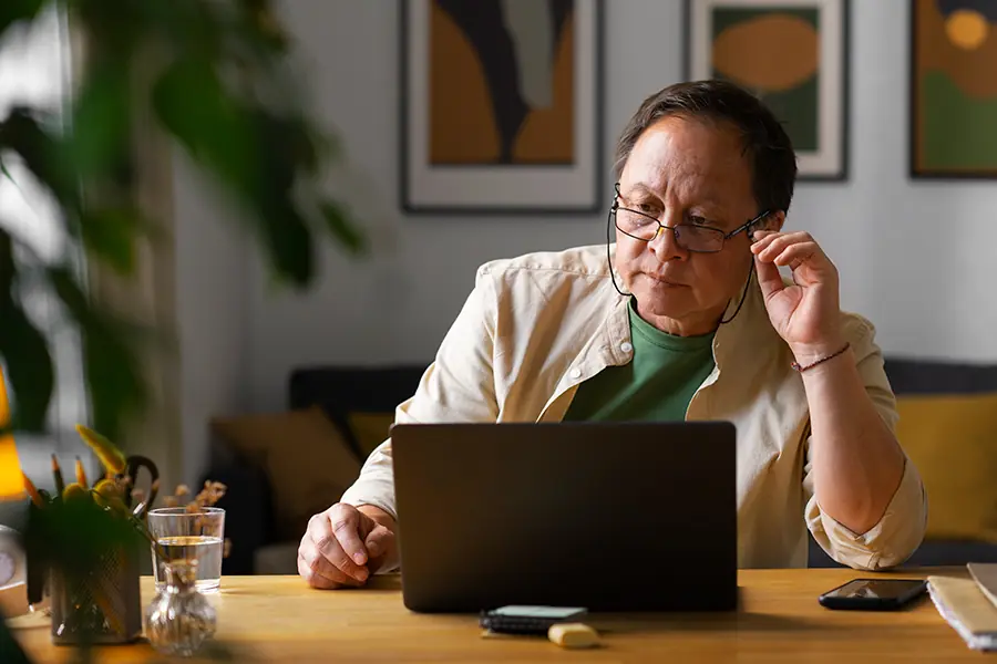 Portrait of older man using laptop at home