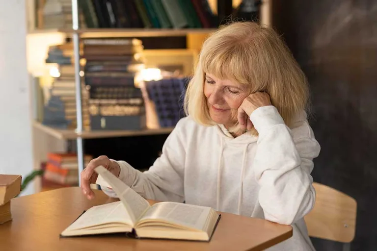 Older woman reading a book at home